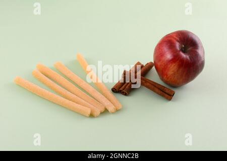 Strudel di mele e cannella gummy bastoncini con mela fresca e cannella su sfondo verde chiaro Foto Stock