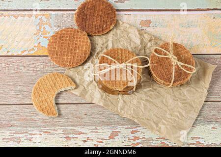 Impilare stropwafer su carta marrone, accanto ad un altro biscotto con un boccone. Foto Stock