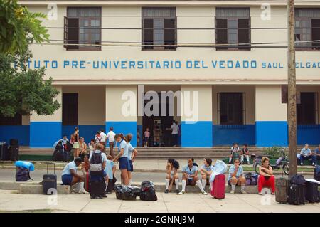 L'Avana, Cuba - 13 novembre 2006: Alunni e genitori con bagaglio in attesa di trasporto all'esterno dell'Istituto Pre-Universitario del Vedado in cit Foto Stock