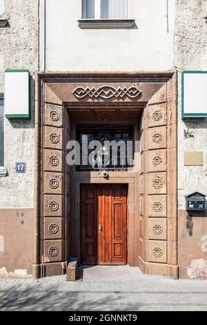 Una vecchia porta in legno d'epoca nella parte anteriore della casa, splendidamente decorata con monogrammi Foto Stock