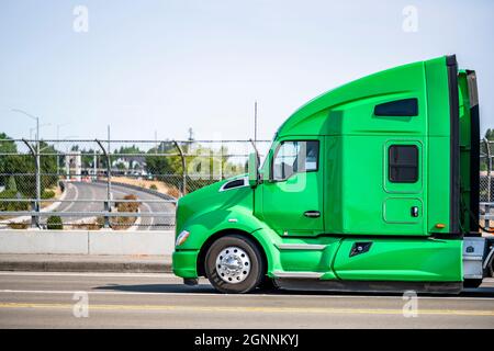 Verde elegante cofano trattore semi-camion con carro grande e vano Sleeping Cab per il resto del conducente del camion che trasporta il carico in semirimorchio con copertura nera r Foto Stock