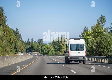 Mini furgone industriale compatto bianco di piccole dimensioni con vano di carico per le consegne locali e le esigenze delle piccole imprese che funzionano sull'ampia linea highwa multilinea Foto Stock