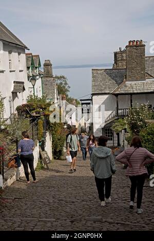 Visotrs camminando su strada ciottolata vicino al New Inn Hotel nell'antico villaggio di Clovelly North Devon Foto Stock