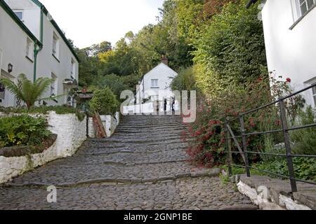 Case bianche su entrambi i lati della strada acciottolata costruita da ciottoli dalla spiaggia nel villaggio antico di Clovelly dove Charles Kingsley visse come Foto Stock