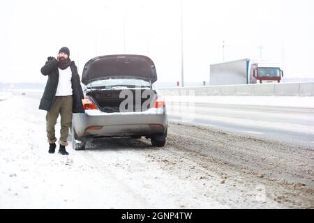 Outdoor ritratto di uomo bello in cappotto e scurf. Casual moda invernale Foto Stock