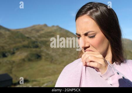 Donna disgustata che puzzava abiti stinky in montagna Foto Stock