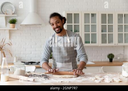 Testa ritratto sorridente afroamericano uomo stendendo pasta Foto Stock
