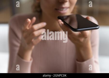 Primo piano di donna parlare su altoparlante sul cellulare Foto Stock