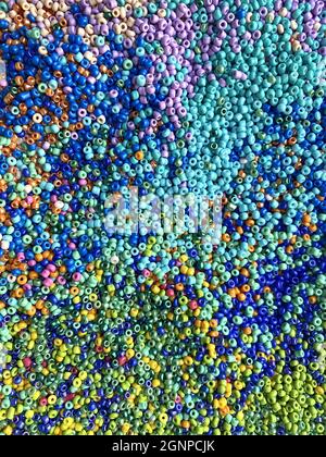 Colpo verticale di molti vortici colorati di minuscoli grani di seme Foto Stock