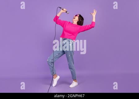 Vista completa del corpo di dimensioni di attraente talento ragazza gallegra cantare divertirsi isolato su viola sfondo di colore viola Foto Stock