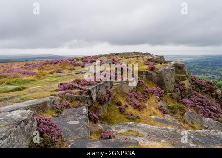 La bassa nuvola grigia si trova sopra Baslow Edge e la campagna del Derbyshire in una mattinata estiva. Foto Stock