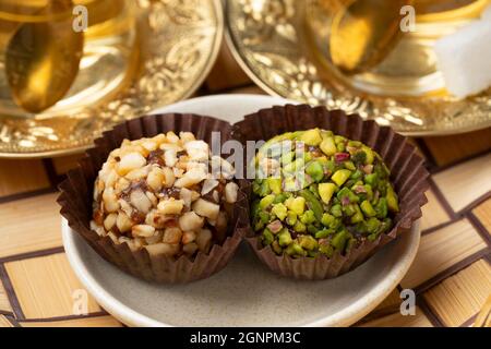 Coppia di dolci datero Turkisch decorati con noci davanti ai bicchieri da tè Foto Stock