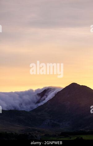 Sera nebbia che rotola attraverso la cima di una montagna a Snowdonia, Galles, Regno Unito Foto Stock