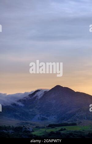 Sera nebbia che rotola attraverso la cima di una montagna a Snowdonia, Galles, Regno Unito Foto Stock