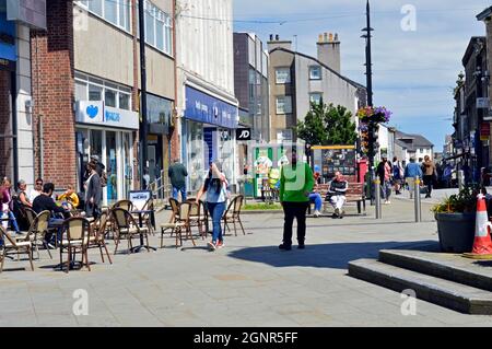 BANGOR, GWYNEDD.WALES. 06-26-21. Hight Street nel centro della città. La gente sedette ai tavoli del marciapiede vicino alla torre dell'orologio. Foto Stock