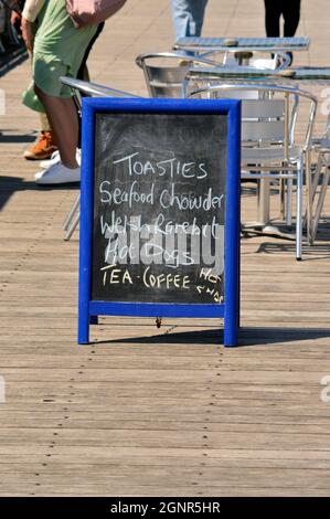 BANGOR. GWYNEDD. Galles. 06-26-21. Il molo, il menu a bordo fuori di uno dei chioschi caffè pubblicità le specialità del giorno. Foto Stock