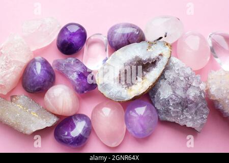 Belle gemme, geode ametista e drusi di ametista minerale viola naturale su uno sfondo rosa. Ametisti e quarzo rosa. Grandi cristalli di Foto Stock