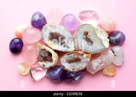 Belle gemme, geode ametista e drusi di ametista minerale viola naturale su uno sfondo rosa. Ametisti e quarzo rosa. Grandi cristalli di Foto Stock