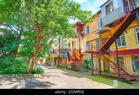 Il piccolo cortile con alberi ombrosi, vestiti essiccanti e mura della casa ombreggiato, Odessa, Ucraina Foto Stock