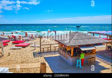 La piccola capanna di legno con tetto di paglia è un bar sulla spiaggia, situato sulla costa del Mar Nero a Odessa, Ucraina Foto Stock