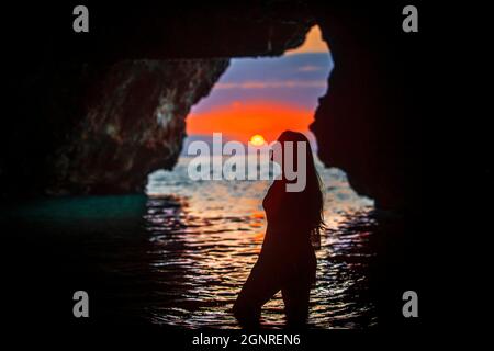 Alba all'interno di Cova del Llop Marí a Hospitalet de l'Infant Vandellòs Costa Dorada Tarragona Catalonia Spagna è una grotta sulla costa dove una spiaggia Foto Stock