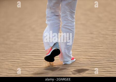 Donna escursioni in dune di sabbia desertica. Primo piano sulle scarpe. Dubai. Emirati Arabi Uniti. Foto Stock