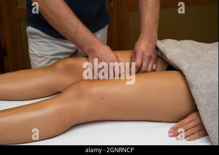 Donna ottenere gambe linfodrenaggio massaggio in centro termale. Primo piano. Relax del corpo bellezza e cura del corpo concetto. Foto Stock