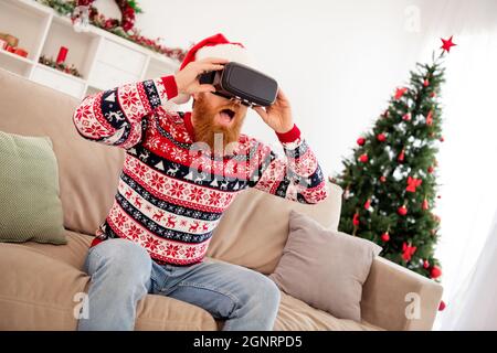 Ritratto di foto uomo ported indossando occhiali 3d guardando la realtà virtuale in headwear indossare headwear vicino albero di natale Foto Stock