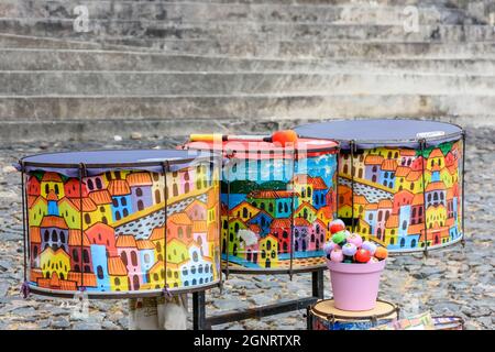Etnico e colorato set di tamburi dipinti a mano sulle strade di Pelourinho, Salvador, Bahia Foto Stock