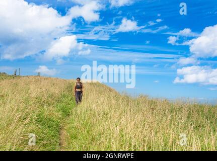 Donna sul sentiero costiero Cleveland Way su alcune delle scogliere più alte in Inghilterra sulla sezione Saltburn to Staithes. North Yorkshire, Inghilterra. REGNO UNITO Foto Stock