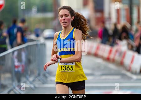 Warrington Running Festival 2021 - la donna ferma il suo orologio come lei finisce la corsa Foto Stock