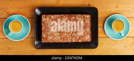 Torta al cioccolato fatta in casa e due tazze di caffè espresso su un tavolo di legno. Vista dall'alto. Foto Stock