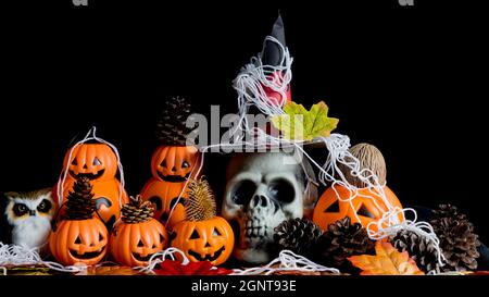 Halloween cranio umano, Halloween Pumpkins su un vecchio tavolo di legno di fronte a sfondo nero con spazio libero per il testo. Concetti di Halloween. Happy Hall Foto Stock