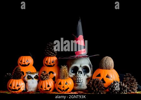 Halloween cranio umano, Halloween Pumpkins su un vecchio tavolo di legno di fronte a sfondo nero con spazio libero per il testo. Concetti di Halloween. Happy Hall Foto Stock