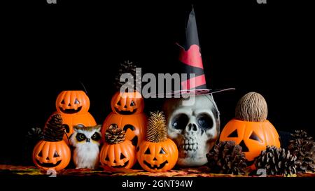 Halloween cranio umano, Halloween Pumpkins su un vecchio tavolo di legno di fronte a sfondo nero con spazio libero per il testo. Concetti di Halloween. Happy Hall Foto Stock