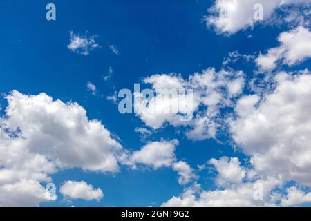 Nuvole di cumulo soffici, bianco e grigio. Cielo blu e nuvole con sole e luce naturale sfondo. Foto Stock