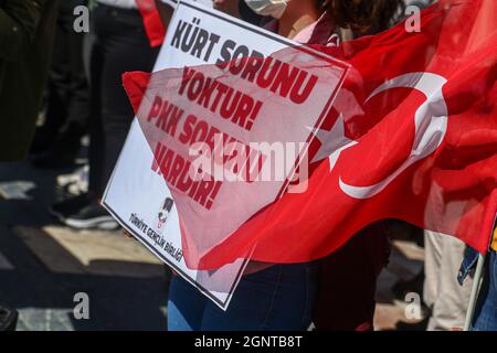 Ankara, Turchia. 27 settembre 2021. La bandiera turca vola accanto al cartello con la scritta "non c'è alcun problema curdo, c'è un problema PKK" durante la manifestazione. L'Unione dei giovani della Turchia (TGB) ha protestato contro il partito democratico dei popoli pro-curdi (HDP) e il partito dei lavoratori Kurdistan (PKK) in piazza Ulus Atatürk. Credit: SOPA Images Limited/Alamy Live News Foto Stock