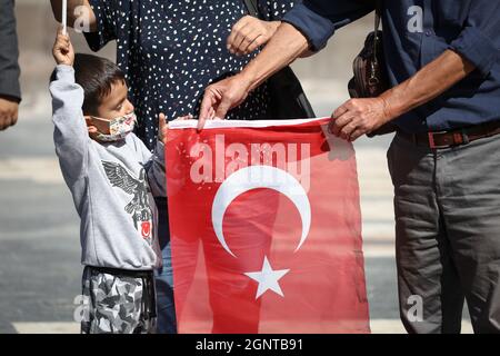 Ankara, Turchia. 27 settembre 2021. Durante la manifestazione, un bambino detiene una bandiera turca con la sua famiglia. L'Unione Giovanile della Turchia (TGB) ha protestato contro il Partito democratico dei popoli pro-curdo (HDP) e il Partito dei lavoratori Kurdistan (PKK) in Piazza Ulus Atatürk. Credit: SOPA Images Limited/Alamy Live News Foto Stock