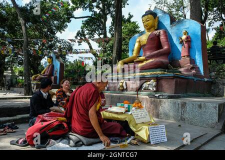Kathmandu, Nepal - Settembre 2021: La gente che fa un'offerta davanti ad una statua del Buddha allo Stupa di Swayambhunath il 25 Settembre 2021 a Kathmandu Foto Stock