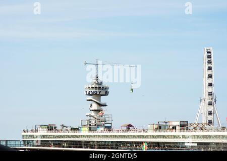 L'Aia, Paesi Bassi - 24 agosto 2021: De Pier a Scheveningen con una gru per bungee jumping e una ruota panoramica Foto Stock