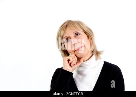 Donna anziana in posizione di pensiero con la mano sul viso. Sfondo bianco. Circa 65 anni donna. Foto Stock