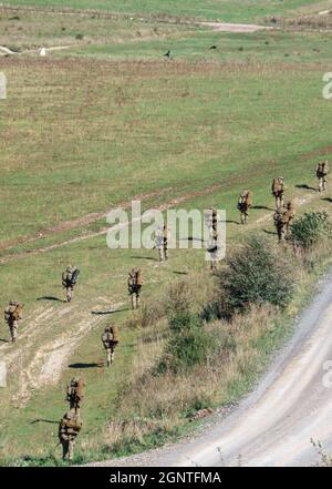 Esercito britannico GCC soldati di fanteria su una scheda di prova di addestramento di combattimento 4km che trasporta 40kg attraverso Salisbury Plain Wiltshire Regno Unito Foto Stock