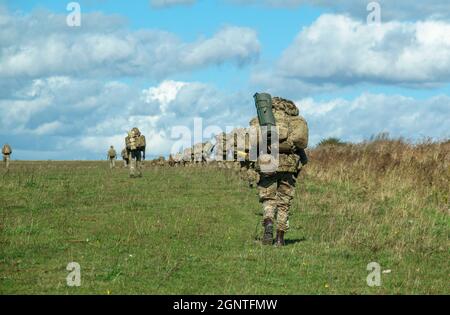 Esercito britannico GCC soldati di fanteria su una scheda di prova di addestramento di combattimento 4km che trasporta 40kg attraverso Salisbury Plain Wiltshire Regno Unito Foto Stock