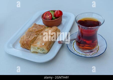 Colazione tradizionale turca, tè, pasticceria all'acqua e pomodoro, cetrioli. Foto Stock