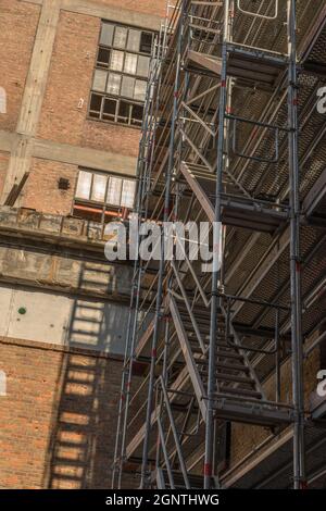 Impalcatura sulla facciata di una ex fabbrica Foto Stock