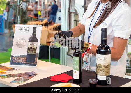 Alicante, spagna. 09-26-2021 donna che serve vino (Altos de Orihuela) per la degustazione alla fiera gastronomica di Alicante. Foto Stock