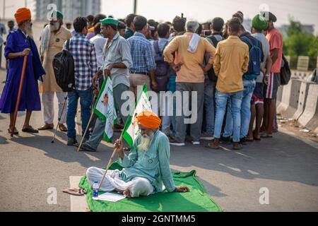 Ghaziabad, India. 27 settembre 2021. Un agricoltore detiene una bandiera dell'Unione di Bhartiya Kisan durante uno sciopero a livello nazionale contro le riforme agricole al confine Delhi-Uttar Pradesh.migliaia di agricoltori indiani hanno bloccato il traffico sulle strade principali e sulle linee ferroviarie in diversi luoghi dalla mattina come lo spegnimento chiamato dal Samyukta Kisan Morcha (Farmer Union Body), un corpo ombrello di 40 sindacati contadini è stato avviato, il blocco è stato revocato alle 16. (Foto di Pradeep Gaur/SOPA Images/Sipa USA) Credit: Sipa USA/Alamy Live News Foto Stock