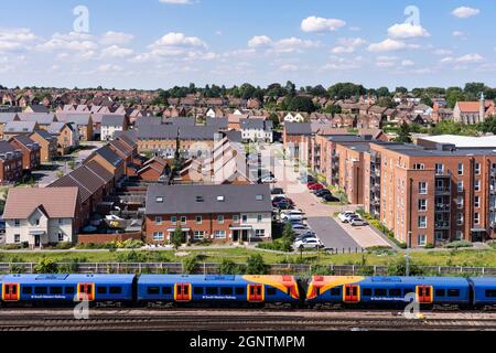 Vista aerea su una linea ferroviaria e abitazioni miste - blocchi di appartamenti, case indipendenti e semi-indipendenti - nella tenuta Chapel Gate, Basingstoke, Regno Unito Foto Stock