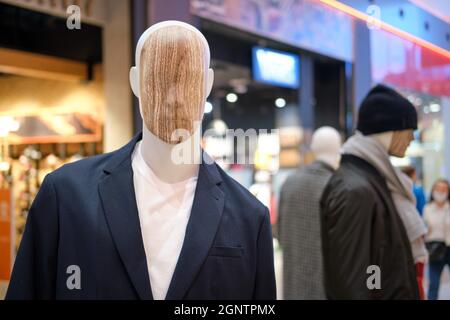 Manichini in abiti sullo sfondo dei negozi del centro commerciale Foto Stock