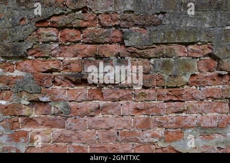 Vecchio muro usurato che mostra profondamente testurizzato rosso intemperie mattoni con spazio copia Foto Stock